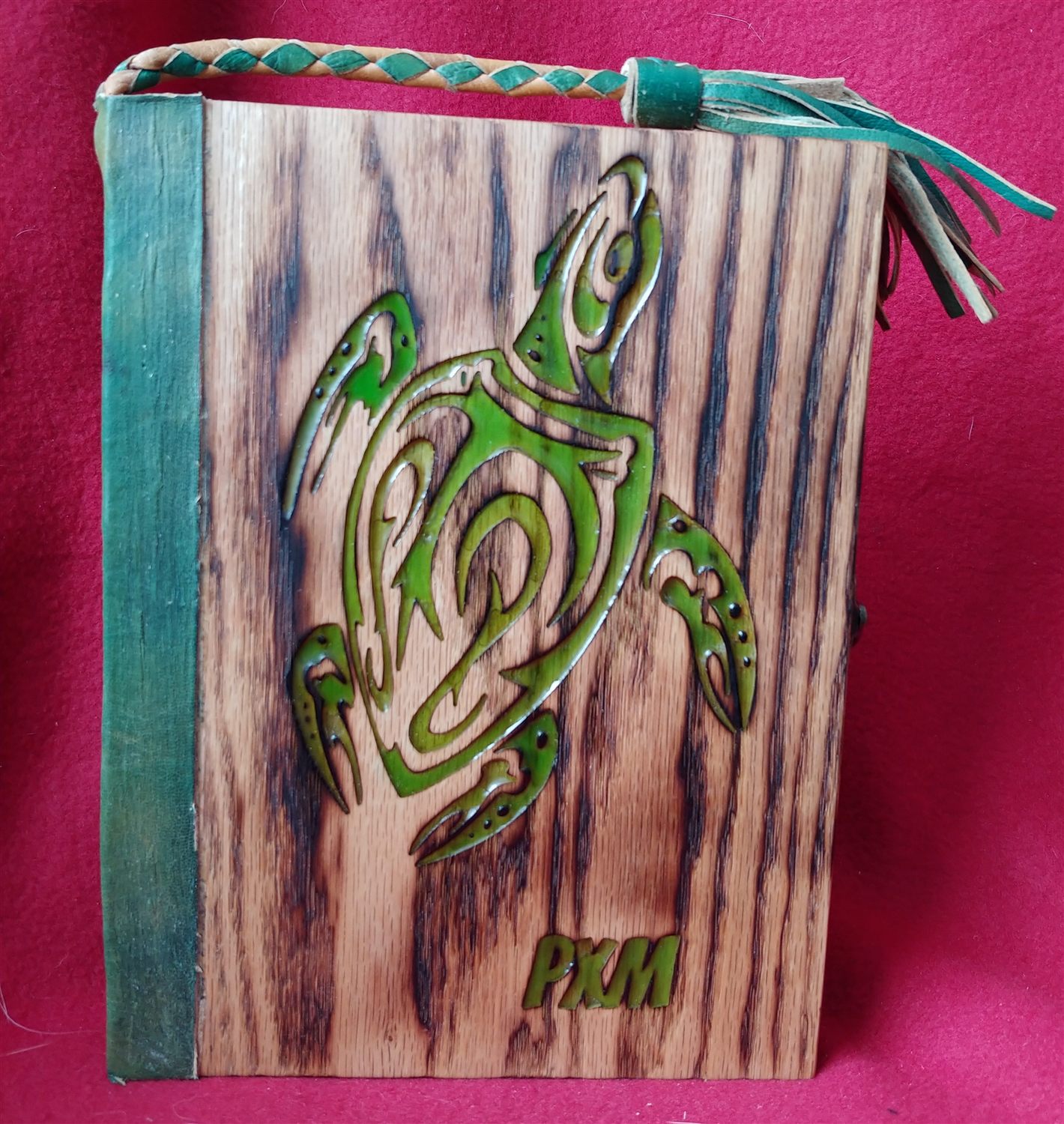 A book-style wooden D&D dice box with a sea-turtle CNC-engraved and resin-filled into the torched-oak cover, and a leather tassel.